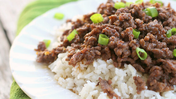 Picture of Cheater Korean Beef served over rice on a white plate.